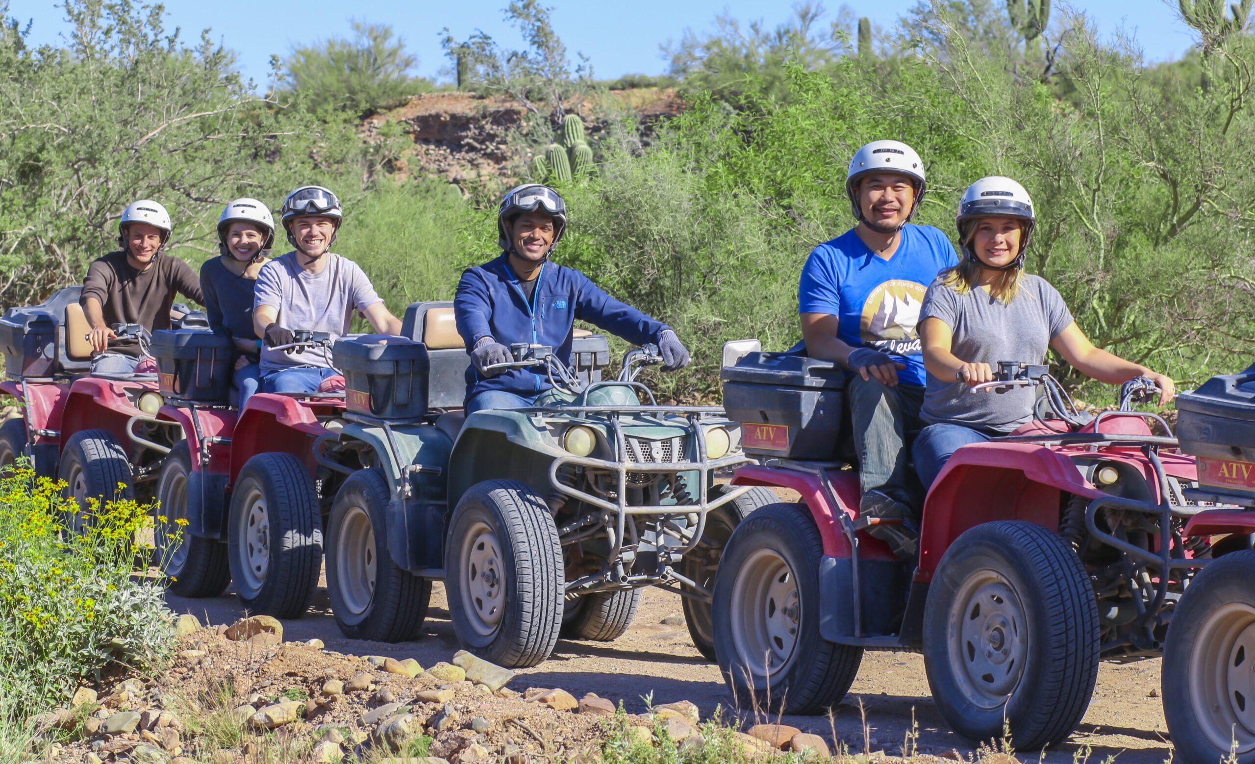 Majestic red rock landscapes of Sedona, vibrant blue sky, thrilling ATVs navigating rugged trails, stunning desert flora, dramatic cliffs in the background, dust clouds rising as vehicles speed through the terrain, serene natural beauty juxtaposed with adventurous spirit.