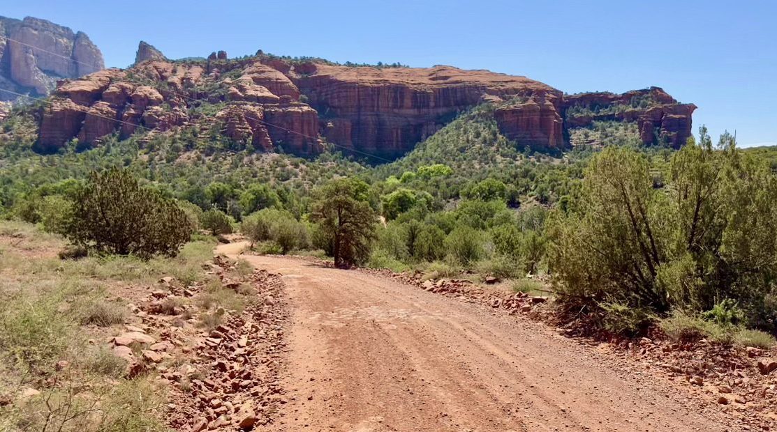 A rugged all-terrain vehicle navigating through the stunning red rock formations of Sedona, Arizona, surrounded by vibrant desert vegetation and a clear blue sky, capturing the essence of adventure and exploration.