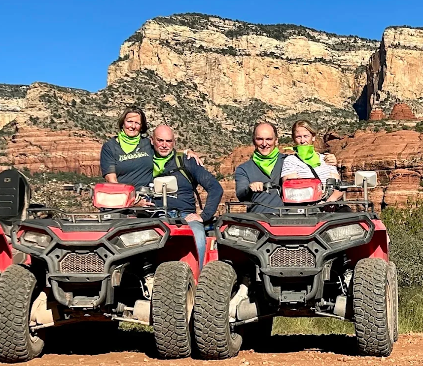 A group of people posing for a photo in front of their ATV's