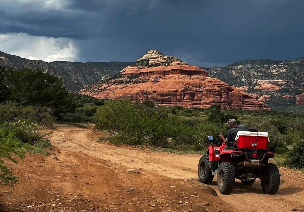 a ATV parked on the side of a dirt road