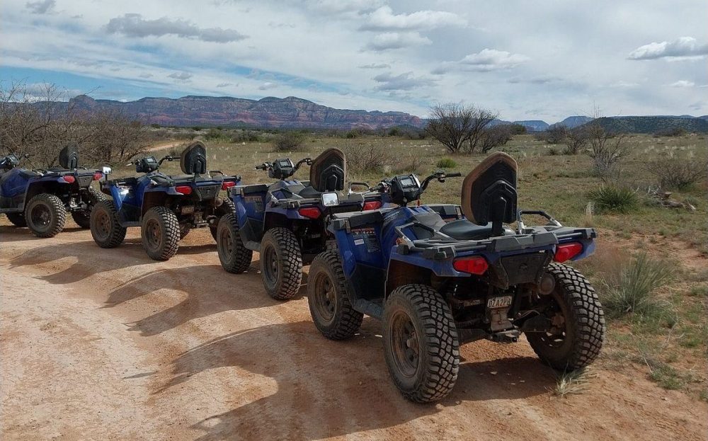 Vibrant off-road ATV adventure through the stunning red rock formations of Sedona, Arizona, with dramatic cliffs and bright blue skies, showcasing dynamic motion and rugged terrain, surrounded by lush desert vegetation.